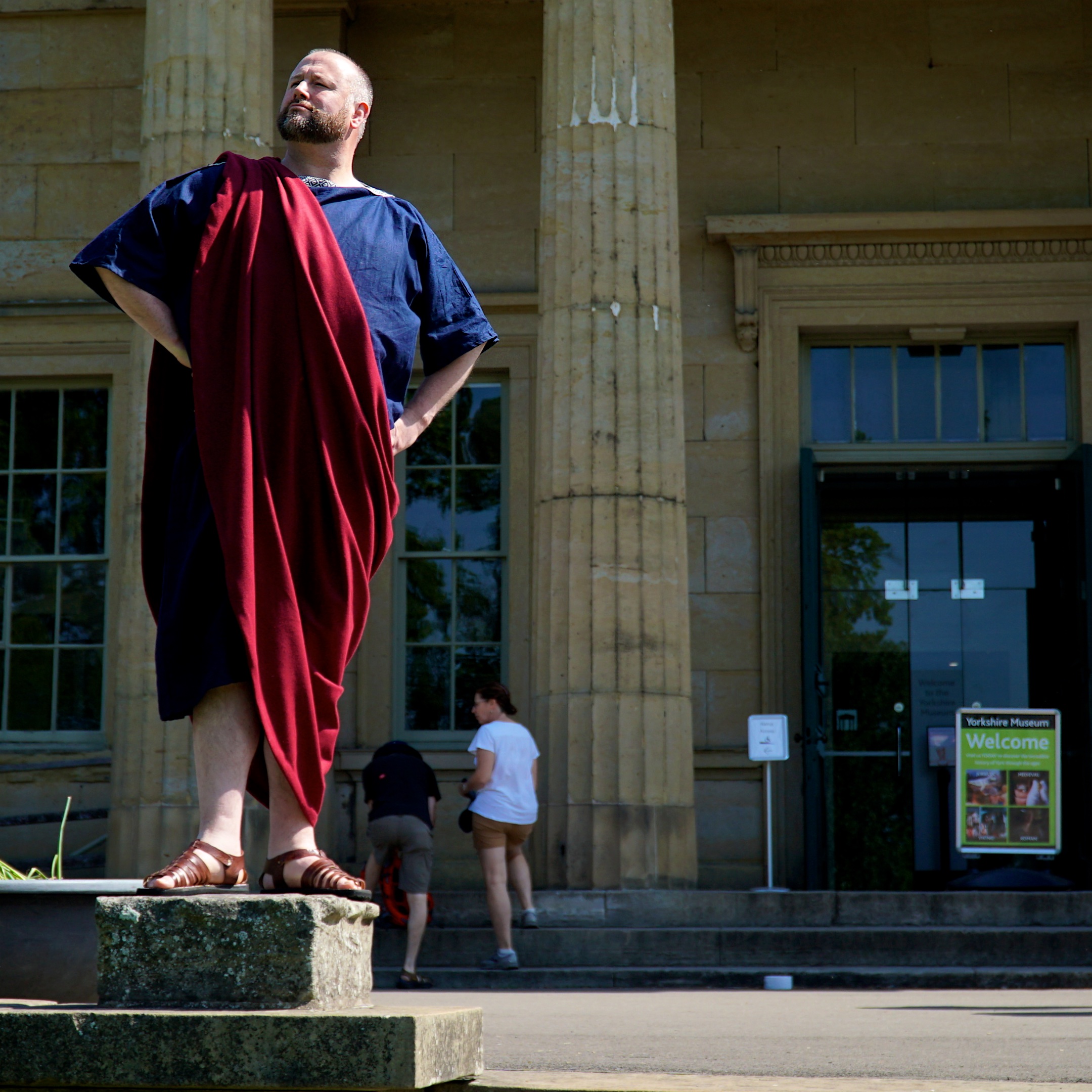 A Roman stands looking self-important in front of the classical cloumns of the Yorkshire Musuem in York