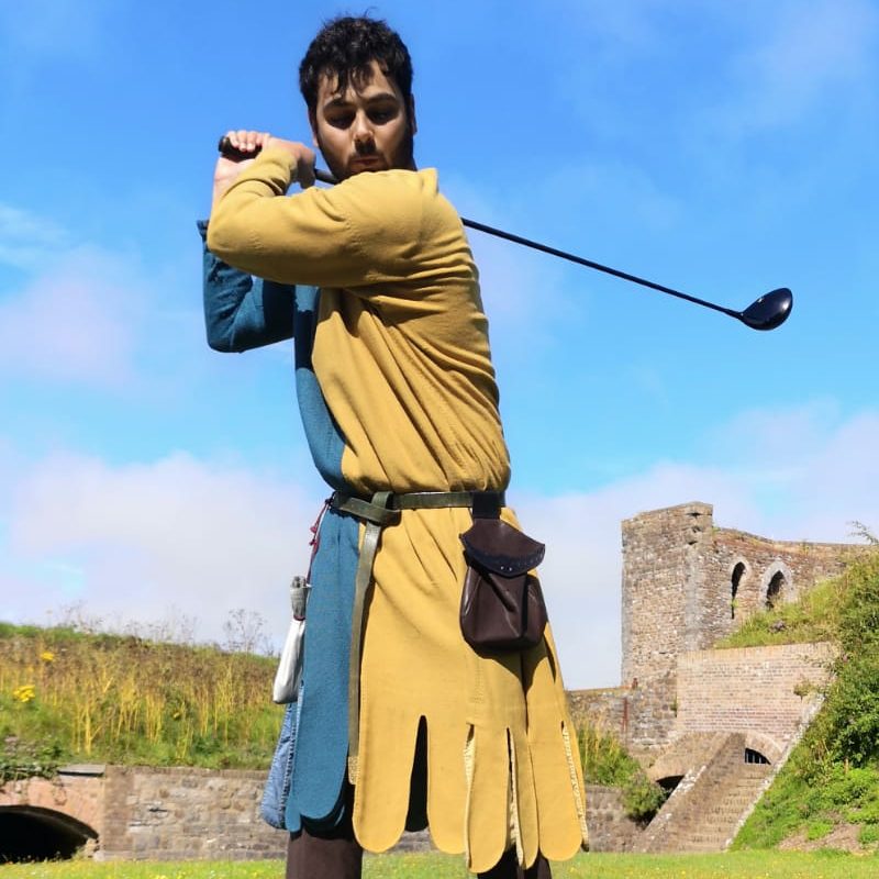 A medieval man playing golf in the grounds of Dover Castle